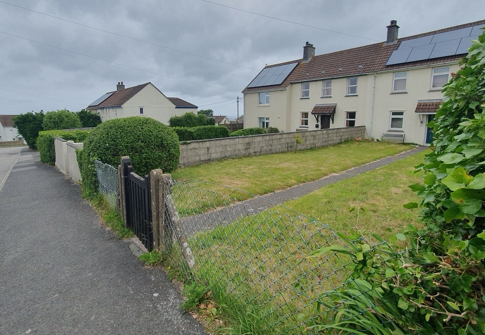 Houses with roof panels above a long open lawn on Porthia Road in St Ives, Cornwall