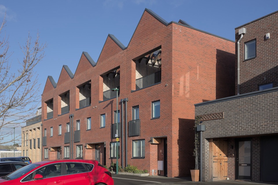 Brick terraced houses with timber lined balcony recesses at Trent Basin in Nottingham